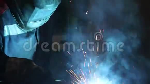 穿着防护服和面罩的焊工焊接金属结构视频的预览图
