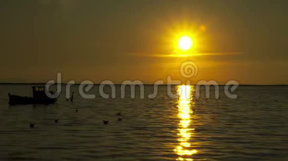 漂浮在海上夕阳下的木制渔船视频的预览图