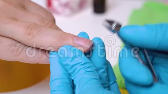 特写客户的手和指甲主人在处理指甲手套用切割机指甲护理视频的预览图
