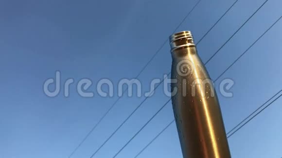 日落背景下带盖的钢制热瓶特写视频的预览图