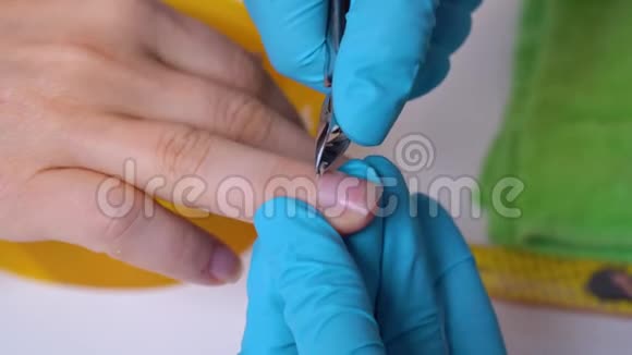 特写客户的手和指甲主人在处理指甲手套用切割机指甲护理视频的预览图