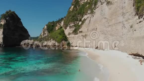 鸟瞰热带海滩海岩绿松石海洋和棕榈树无人机上升努沙佩尼达岛Atuh海滩视频的预览图
