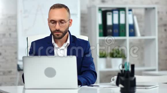 自信的男办公室职员戴着律师眼镜用手提电脑看屏幕视频的预览图