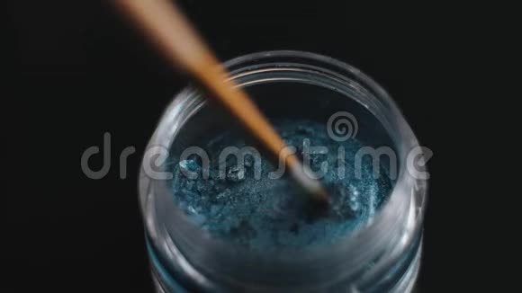 女孩在玻璃罐子里搅动蓝色的干水彩画视频的预览图