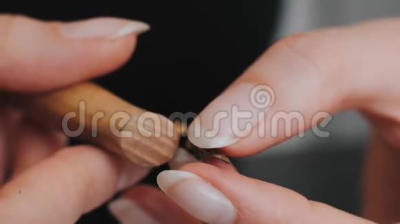女孩在木笔上插入一支笔用于黑色背景上的书法视频的预览图