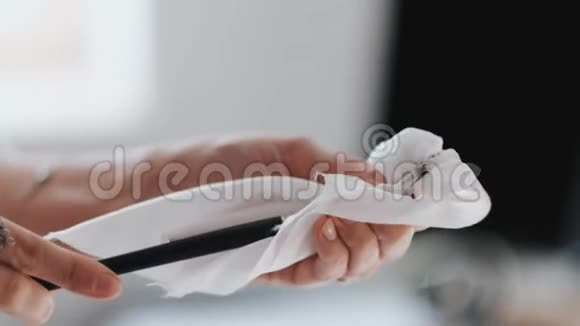 女孩在一块白布上擦一把脏油漆刷视频的预览图