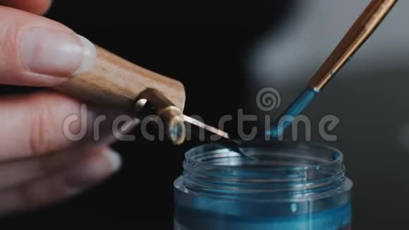 女孩用蓝色睫毛膏浸泡书法笔视频的预览图