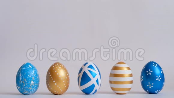 鸡蛋在白色的桌子上滚动互相敲门复活节金色装饰的彩蛋在白色背景上分离最小视频的预览图