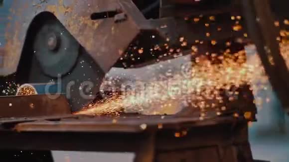 工业工人用大量的锋利研磨金属用生锈的圆形机器锯管子的火花特写视频的预览图