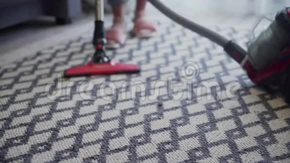 年轻女子用吸尘器清洁地毯视频的预览图