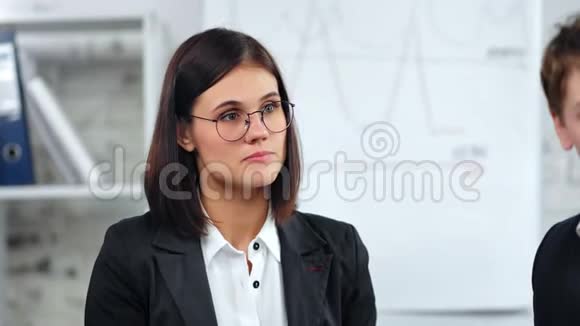 在公司会议期间密切关注自信的商界女性戴眼镜的同事视频的预览图
