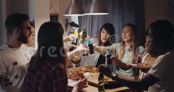 年轻快乐的多民族朋友吃披萨和饮料一起在庆祝晚会上举杯庆祝慢动作视频的预览图