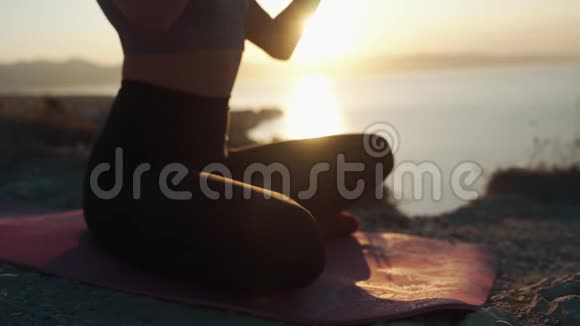 女性身体的一部分坐在莲花位置做瑜伽运动冥想视频的预览图