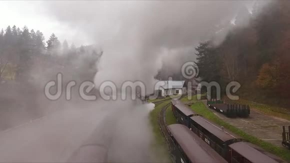 从山上火车站的老火车的烟雾中鸟瞰视频的预览图