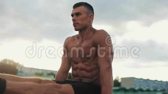 一位肌肉发达的运动员在户外健身房锻炼的近景视频的预览图