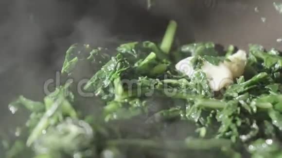 用大蒜炒锅里的菊苣蔬菜用蒸汽煮视频的预览图