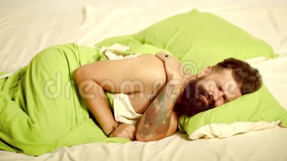 一个长胡子的嬉皮士睡眠有问题睡觉男人睡在床上睡得很深帅哥照片视频的预览图