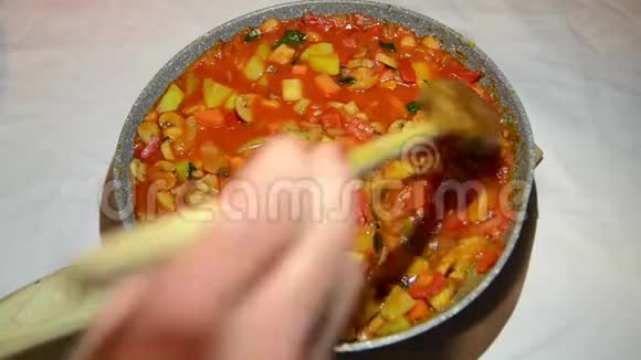 女人在热锅里炒蔬菜关门自制烹饪蔬菜在厨房炒女人手拿着铲子视频的预览图