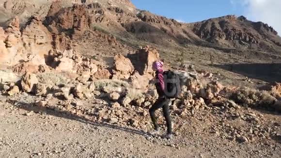 一位年轻女子徒步旅行者的剪影背着背包朝泰德火山口的山顶走去慢慢视频的预览图