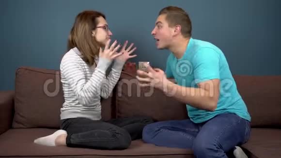 年轻的男人和女人互相尖叫家庭争吵两个人坐在沙发上互相对抗视频的预览图
