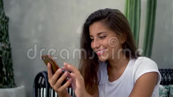 深色皮肤的黑发女孩在电话里发短信视频的预览图