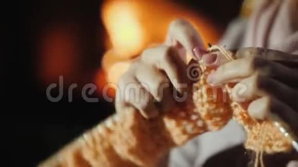 圣诞节前在壁炉旁过夜一个女人编织温暖的衣服视频的预览图