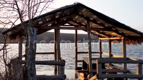 一个手工制作的木制凉亭矗立在水里河边的凉亭视频的预览图