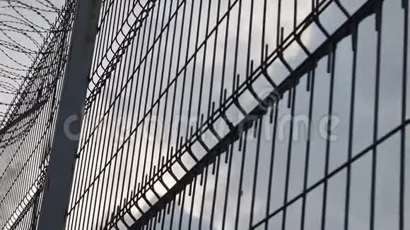 高监狱围栏带刺铁丝网底景监狱的栅栏挡住了晴朗的天空自由概念视频的预览图