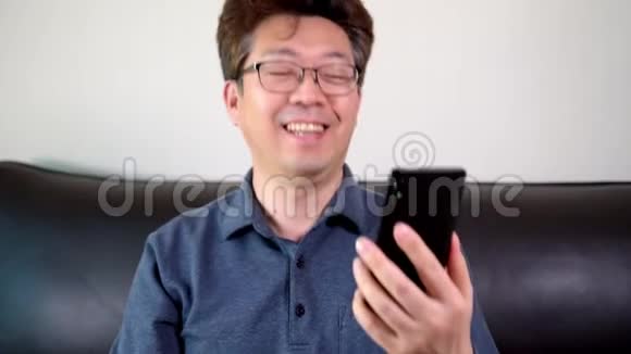 亚洲中年男人用智能手机打了一个快乐的视频电话视频的预览图