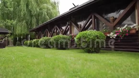 有绿草灌木和树木的木制凉亭视频的预览图