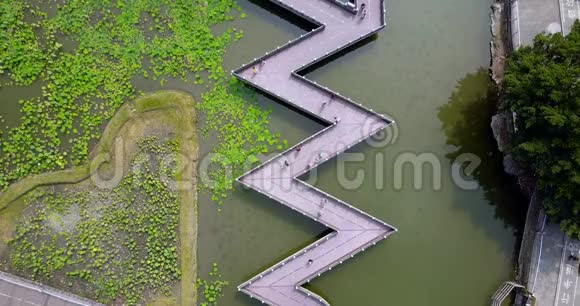 空中镜头的人走通过锯齿状的桥在湖上视频的预览图