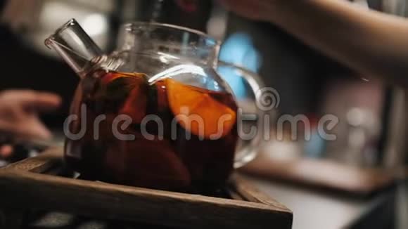 在玻璃茶壶中用沸水冲泡美味的芳香水果茶视频的预览图