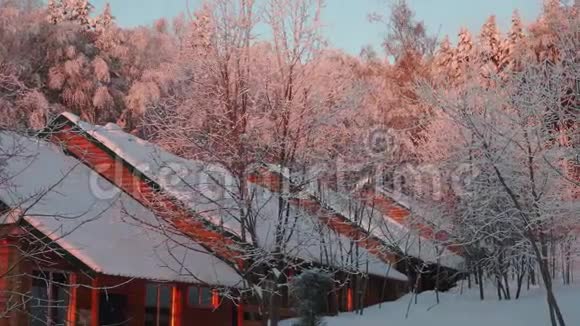 冬季森林和红色日出中的小木屋视频的预览图