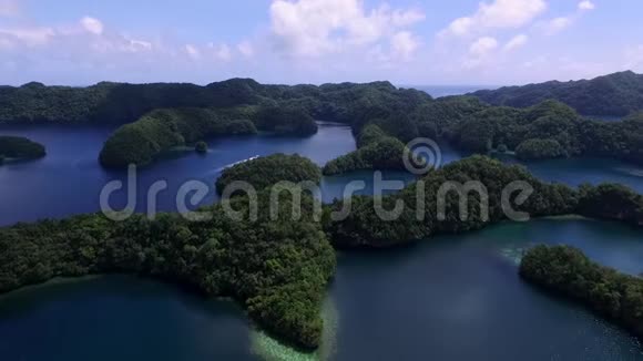 科罗岛的鸟瞰图许多绿色小岛帕劳海相带着五颜六色的珊瑚礁和热带泻湖背景船视频的预览图
