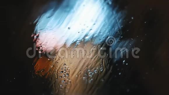 背景下汽车挡风玻璃上滴下的水滴和雪视频的预览图