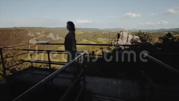后景美丽少女站在观景台欣赏高山美景慢动作视频的预览图