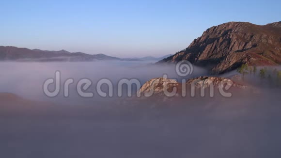黎明时的鸟瞰雾中云层上方的山视频的预览图