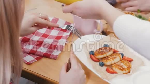 一对夫妇在咖啡馆吃午餐女服务员在小煎饼上倒了一杯糖浆视频的预览图