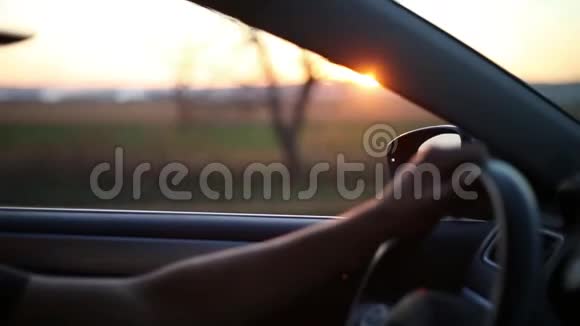 司机手臂特写挥手走出车窗背景夕阳西下视频的预览图
