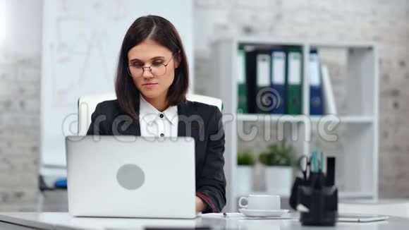 时尚的簿记员女商务经理穿着西装在办公室工作使用笔记本电脑视频的预览图