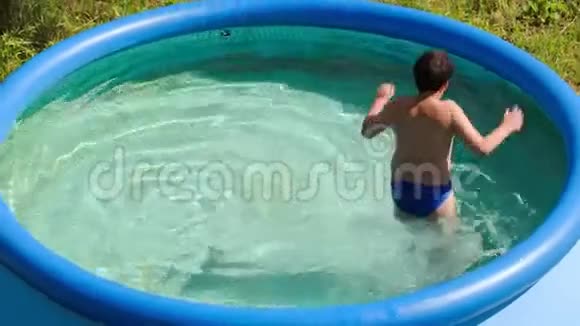 在炎热的夏日在室外游泳池玩耍的男孩视频的预览图