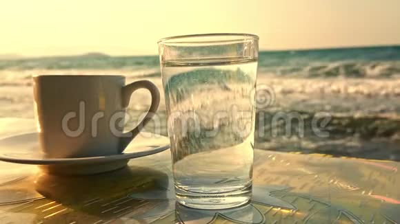 土耳其咖啡带着一杯水的海前和慢动作的海浪视频的预览图