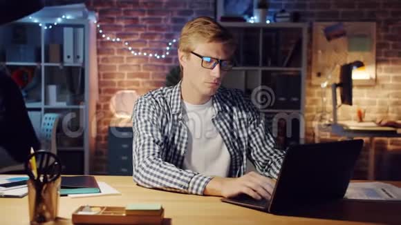 办公室工作人员使用笔记本电脑然后在黑暗的房间里写笔记本视频的预览图