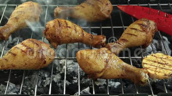烧烤炉上烤鸡腿用铁钳把肉翻过来视频的预览图