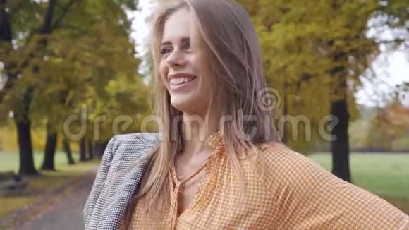 微笑的白人女孩穿上格子夹克看着远处漂亮的深褐色女人穿着芥末视频的预览图