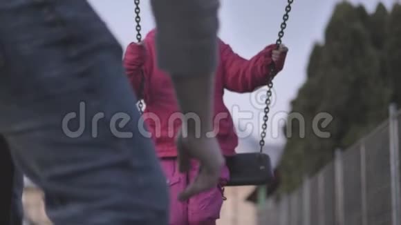 慢动作甜美快乐的五岁小女孩在儿童游乐场的儿童秋千上荡来荡去视频的预览图