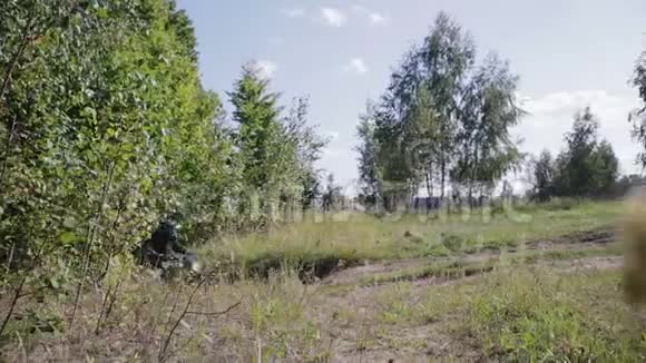 一辆越野摩托车上的摩托车从树林里跳出来跳上一个天然的跳板视频的预览图