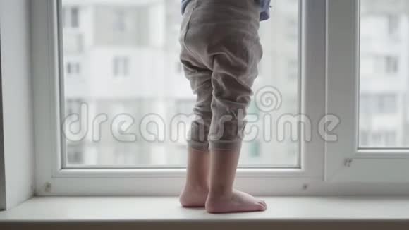 生命危险孩子们的脚踩在窗台上危险的小男孩站在窗户附近视频的预览图