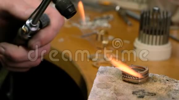 工艺专业珠宝商使用煤气火炬熔化金环金匠加热金属视频的预览图