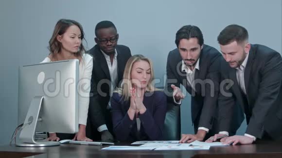 一群多民族多种多样的年轻商人在一次会议上站在一张严肃的桌子旁视频的预览图